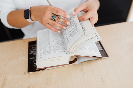 Woman searching for a suitable translation in the dictionary